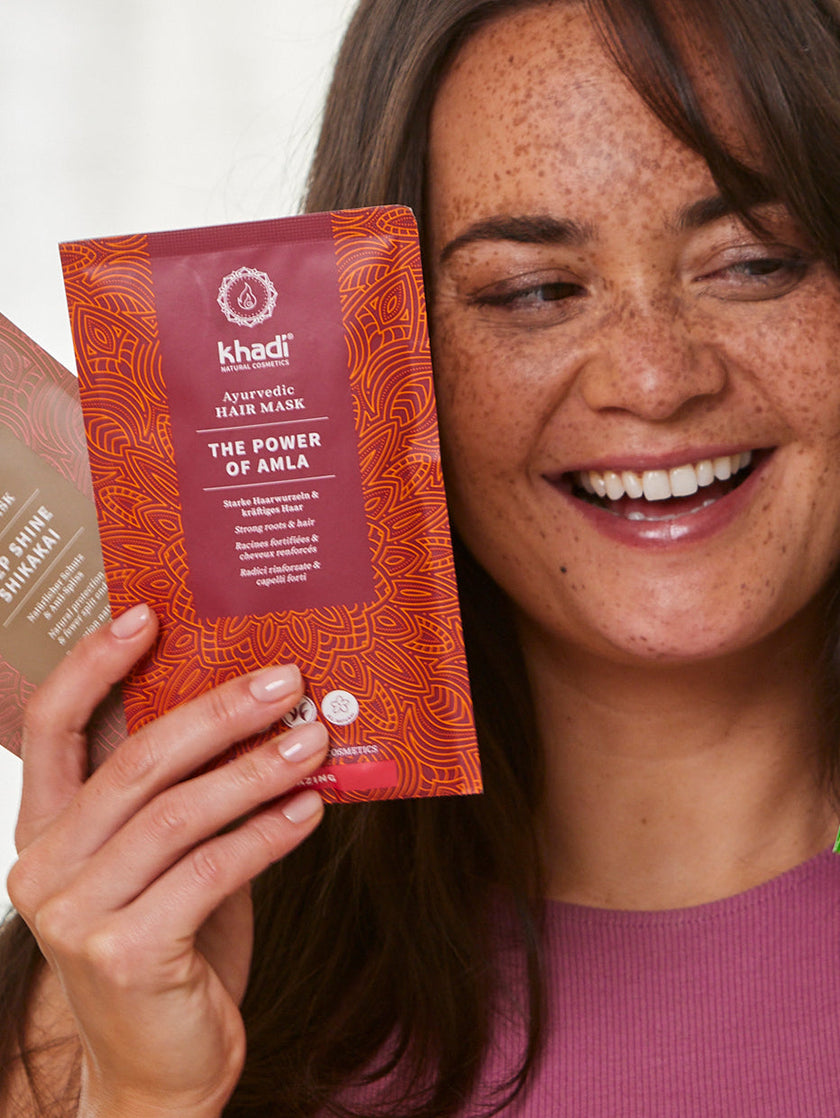 a model holding the natural and ayurvedic hair mask by khadi