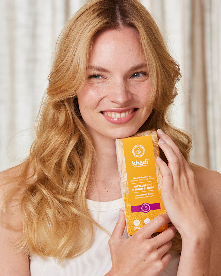 Image of a model holding Medium Blonde natural hair color product by khadi